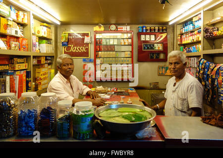 Zwei ältere indische Ladenbesitzer stellen in ihrem Shop Verkauf von Tabakerzeugnissen in Vadodara, Gujarat, Indien. Stockfoto