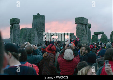 Eine große Menschenmenge von Feiernden und Schaulustige versammeln sich, um die Sommersonnenwende in Stonehenge, Wiltshire, England am 21. Juni Mittsommer-Tag und der längste Tag des Jahres zu erleben. Stockfoto