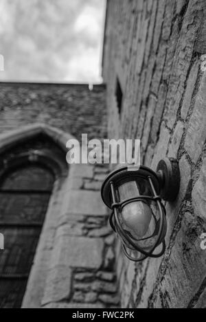 Installierte Sicherheitsleuchte auf der Seite einer alten Kirche installiert, um Verbrechen zu verhindern. Stockfoto