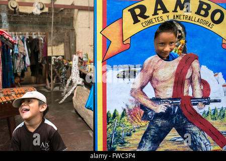 Nim Po't, Souvenir-Shop in Antigua, Guatemala. Kinder haben Spaß mit einer Anzeige für Rambo. Nimpot ist ein Kunsthandwerk-Shop befindet sich in th Stockfoto