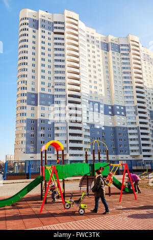 Kinderspielplatz auf dem Hintergrund eines neuen Wohnhauses Stockfoto