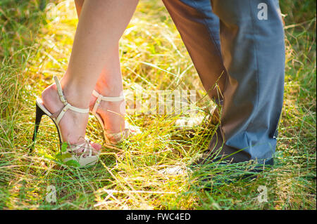 Braut und Bräutigam bleiben auf dem grünen Rasen Stockfoto