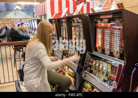 Eine 2P Spielautomat spielt eine Frau in einer Kirmes in einem britischen Badeort. Stockfoto