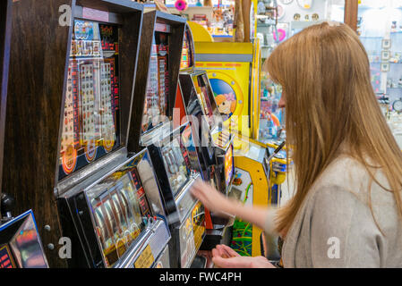 Eine 2P Spielautomat spielt eine Frau in einer Kirmes in einem britischen Badeort. Stockfoto