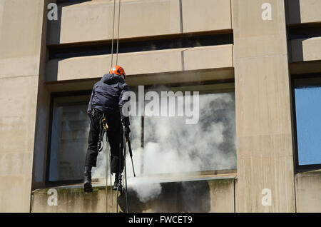 Seilzugang, Abseilen, Fensterreinigung für schwer zugängliche Glas- und Steinarbeiten. Männer, die in der Höhe mit Seilen arbeiten. Person. 10 Frühlingsgärten Stockfoto