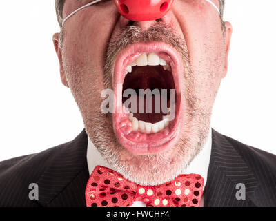 Nahaufnahme Foto eines Mannes in einem Business-Anzug mit einem roten Gumminase und eine funkelnde rote Fliege schreiend in Richtung der Kamera. Stockfoto