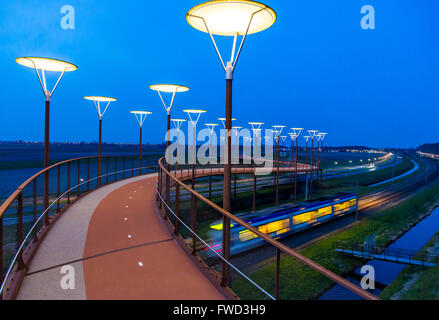 Radweg und Steg, Major Waaijer Brug in Zoetermeer, eine 220 Meter lange, gebogene Brücke über Autobahn und Eisenbahn Spur Stockfoto