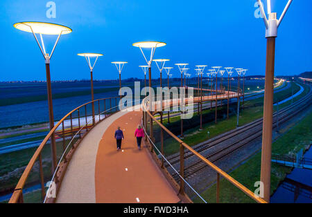 Radweg und Steg, Major Waaijer Brug in Zoetermeer, eine 220 Meter lange, gebogene Brücke über Autobahn und Eisenbahn Spur Stockfoto