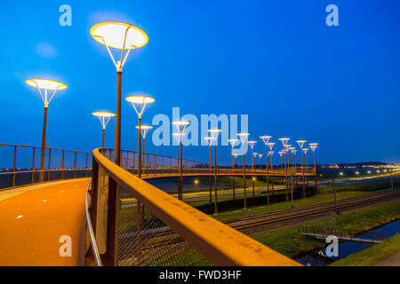 Radweg und Steg, Major Waaijer Brug in Zoetermeer, eine 220 Meter lange, gebogene Brücke über Autobahn und Eisenbahn Spur Stockfoto