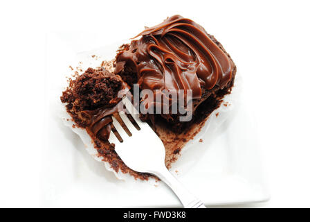 Einen Schokoladen-Brownie mit einer Gabel zu essen Stockfoto