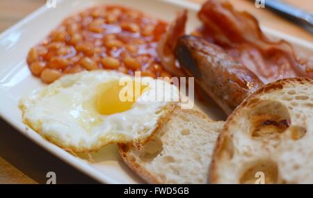 Warmes Frühstück mit Toast, Speck, Spiegelei, Würstchen und Bohnen Stockfoto