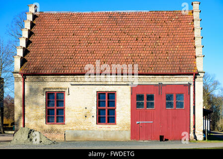 Vittskovle, Schweden - 1. April 2016: Eine alte Lagerhalle mit interessanten architektonischen Details. Großes Fahrzeugtür und zwei w Stockfoto