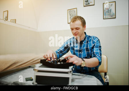 Tattoo-Meister in seinem Salon mit seinem Tattoo-Geräten Stockfoto