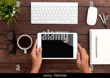 Hand mit weiße Tablette am Arbeitsbereich Stockfoto