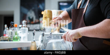 Barkeeper bricht Eis mit Holzhammer Stockfoto