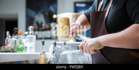 Barkeeper bricht Eis mit Holzhammer Stockfoto