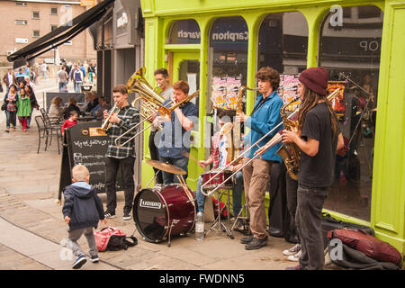 Kleiner Junge eine Spende an eine Straße Band Straßenmusik im Stadtzentrum von Durham in England, UK, Europa Stockfoto