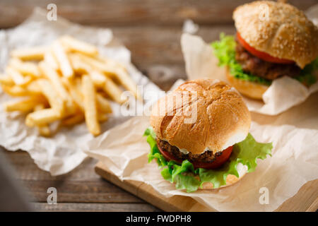 Hausgemachte leckere Burger und Pommes Frites auf Holztisch Stockfoto