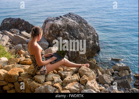 Frauen arbeiten mit Laptop am Ufer Meeres Stockfoto