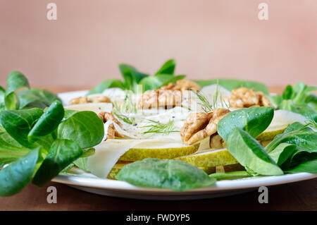 Seitliche Sicht auf einen Teller mit Fenchel, Birne, Walnuss und Parmesan-Salat mit Baby-Spinat und Pappmaché. Stockfoto