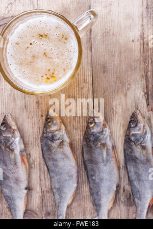 getrockneter Fisch mit Bier auf dem Tisch Draufsicht Hintergrund Stockfoto