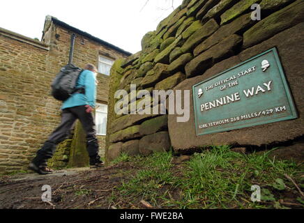 Ein Spaziergänger geht die Zeichen markiert den offiziellen Beginn der Pennine Way National Trail in Edale Dorf, Peak District Derbyshire Stockfoto