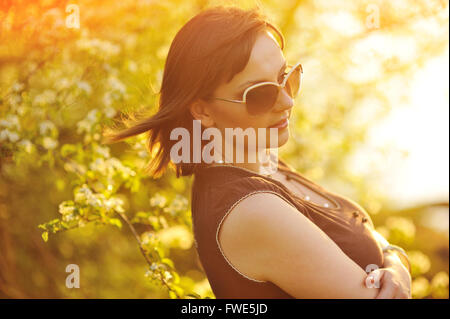 schöne Mädchen auf die Natur in der Nähe von blühenden Bäumen Stockfoto