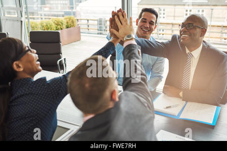 Jubelnder Expertenteam multirassische Jungunternehmen Jubel und gratulieren einander geben eine hohe Fives Geste Stockfoto