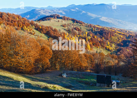 Misty Mountain Herbstlandschaft mit bunten Bäumen am Hang und hölzerne Scheune vor. Stockfoto