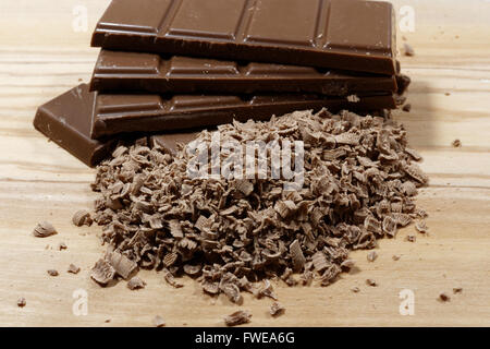 Geriebene Schokolade und Schokolade Bars auf Holzbrett Stockfoto