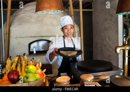 Six Senses Resort, Koh Yao Noi, Bucht von Phang Nga, Thailand, Asien. Kellner mit einem Pfannkuchen in eine Frühstückszeit. Sechs Sinne Yao Noi-Satz Stockfoto
