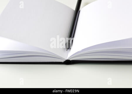 Bleistift auf ein offenes Notebook schwarz Stockfoto