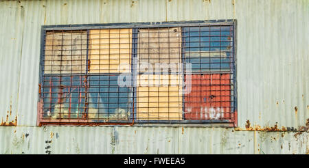 Fensterdetail von einem rostigen alten improvisierten Schuppen hergestellt aus Wellblech. Stockfoto