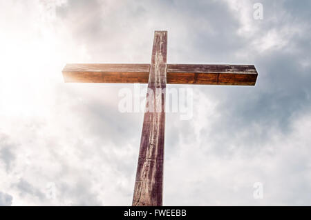 Einfache Holzkreuz gegen den Himmel in Sonnenlicht getaucht. Stockfoto