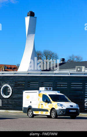 Kivik, Schweden - 1. April 2016: Ein weißer verdrehten Schornstein auf einem schwarzen Gebäude. Ein Peugeot Partner holen mit Logo Buhres 2010 und Stockfoto