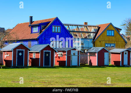 Kivik, Schweden - 1. April 2016: Zwei bunte Häuser sind über eine Glasabteilung untereinander verbunden.  Eine Reihe von kleinen roten Fischen s Stockfoto