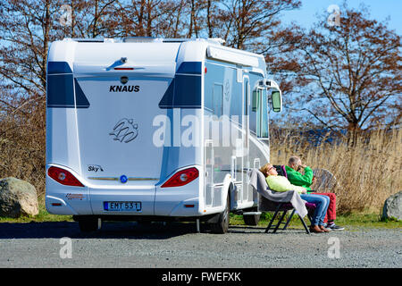 Kivik, Schweden - 1. April 2016: Zwei Personen sitzen in der Sonne draußen ein 2014 Fiat Knaus K250 Aalen. Mann sucht bei mobile Stockfoto