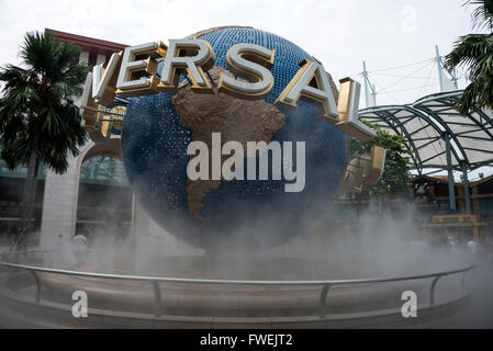 Besucher bewundern die wirbelnden Nebel rund um den drehenden Globus in den Universal Studios auf der Insel Sentosa in Singapur. Stockfoto