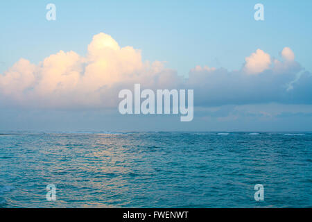 Die gelbe-Orange von der schwindenden Abendlicht trifft diese Wolken genau das richtige und spiegelt sich in dem Wasser auf der Nordküste von Oahu Stockfoto