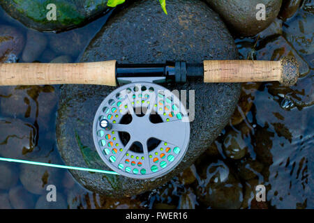 Eine Fliege Angelrute und Rolle sitzen auf einige Flussfelsen am Rande des Willamette River in Oregon. Stockfoto