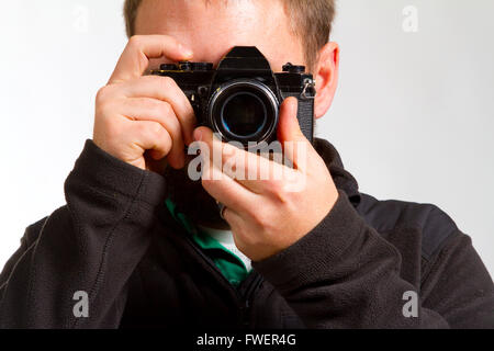 Ein Fotograf hält die Kamera, wie er Fotos schießt. Stockfoto