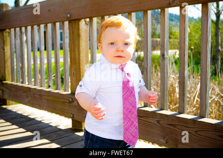 Ein einjähriges Baby junge geht über eine Brücke, die schöne Kleider und eine Krawatte tragen. Stockfoto