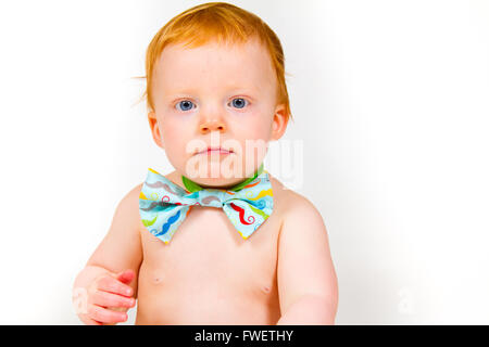 Ein einjähriges Baby junge im Studio mit einem weißen Hintergrund. Das Kind trägt eine Fliege und eine Windel. Stockfoto