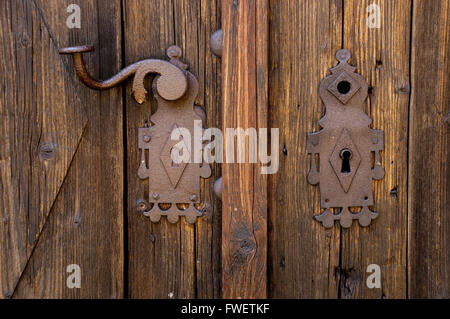 Rostige Rosette Platte auf alte Holztür Stockfoto