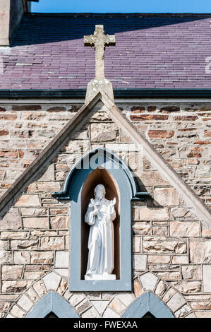 Statue des Hl. Joseph mit einem Kreuz in einer Aussparung einer Kirche an der Wand. Stockfoto