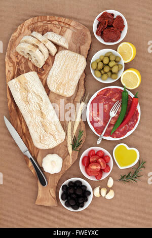 Italienische Antipasti-Auswahl mit Oliven, Salami, Chili Peppers, Sonne getrockneten und frischen Gemüse Olivenöl und Ciabatta-Brot Stockfoto