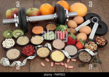 Bodybuilding-Hanteln und Hand Greifer mit Gesundheit und Super Auswahl an Speisen einschließlich Ergänzung Pulver und frisches Obst. Stockfoto
