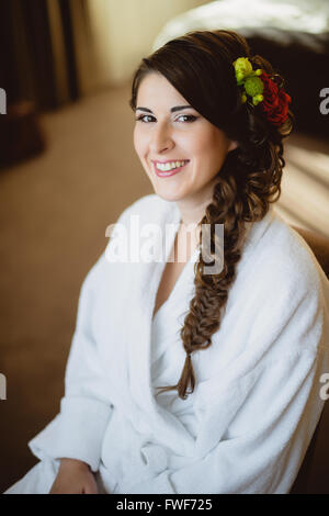 Braut sitzt auf einem Stuhl in weißes Gewand Stockfoto