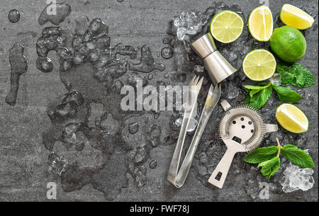 Cocktail trinken macht Werkzeuge und Zutaten mit Eis auf dunklen Stein Hintergrund Stockfoto