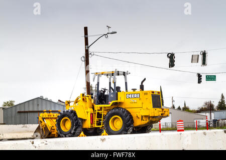 John Deere Radlader vor Ort auf der Baustelle, Autobahn-Brücke, in Modesto, Kalifornien, an einem bewölkten Tag Stockfoto